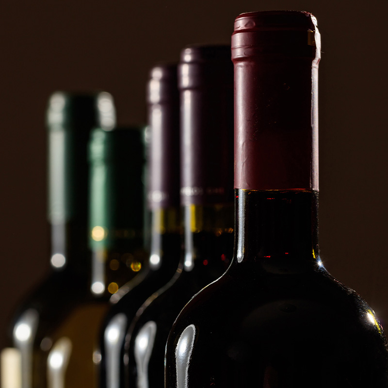 Close up di bottiglie di vino in controluce su sfondo nero